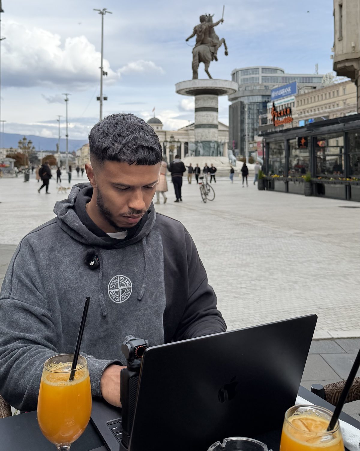 Neno working on his laptop at an outdoor café